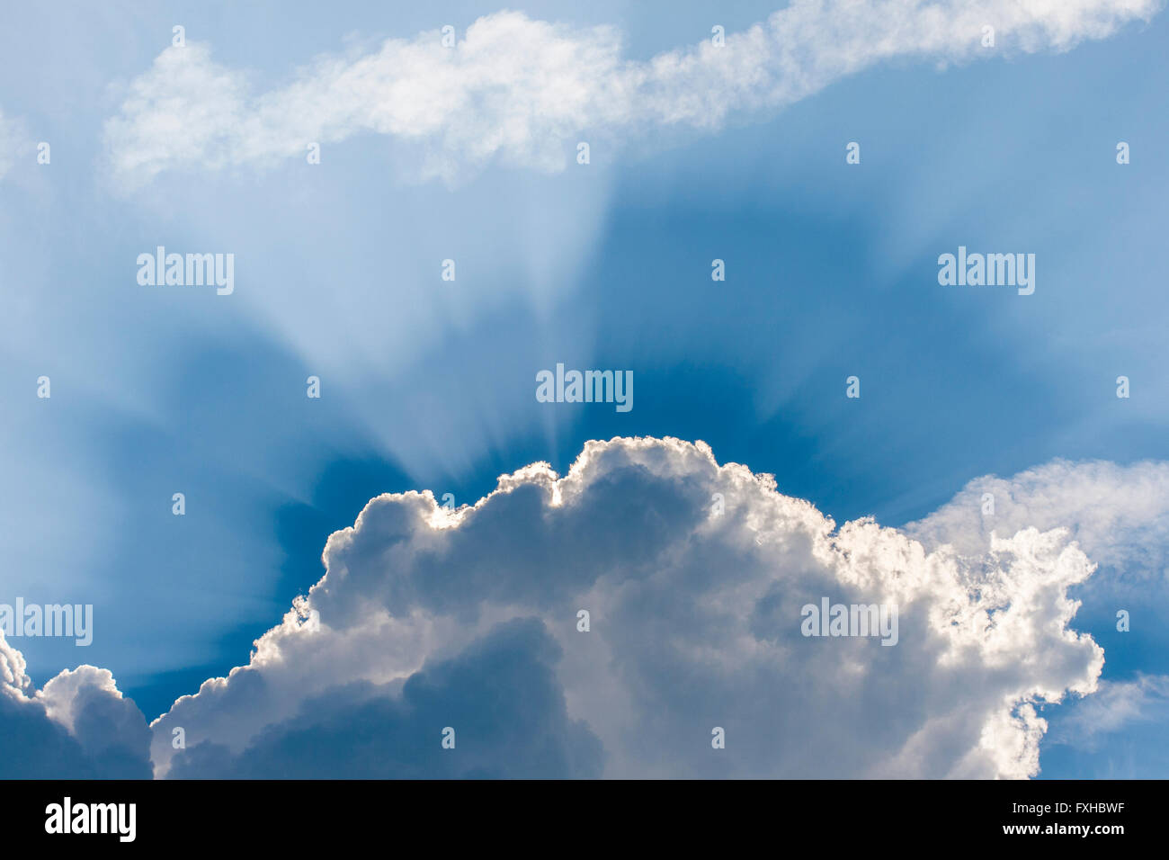 Amazing sun rays coming out from behind the clouds, blue sky Stock Photo