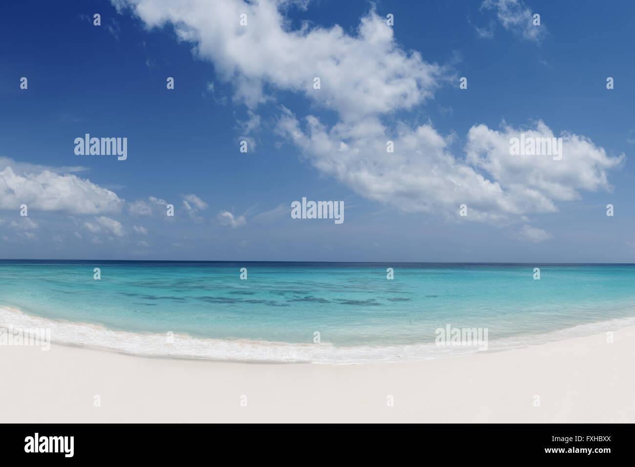 tropical beach with white sand turquoise water and blue cloudy sky ...