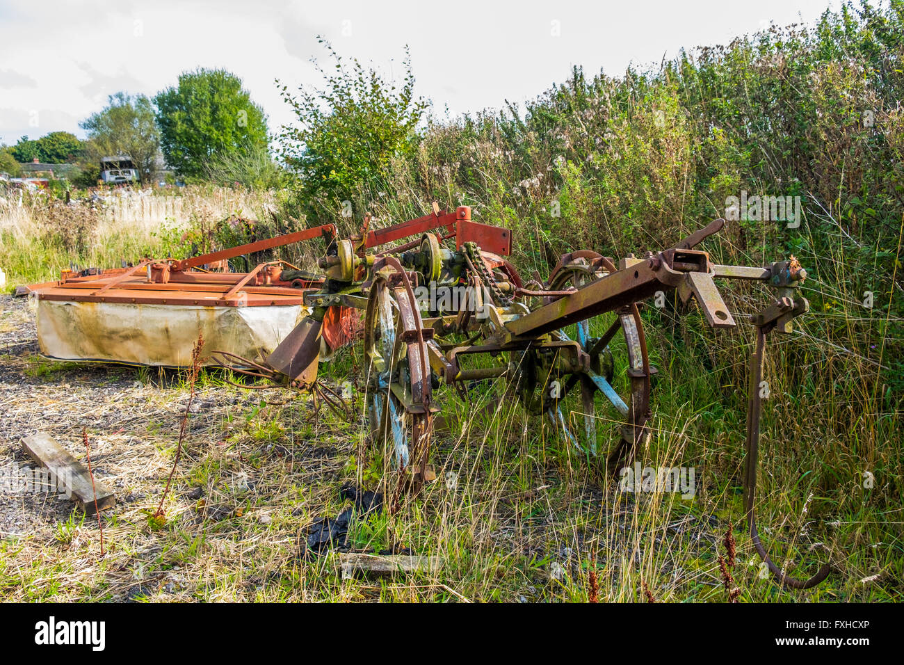 A dilapidated piece of old farmyard machinery left in a field to rust and rot away. Stock Photo