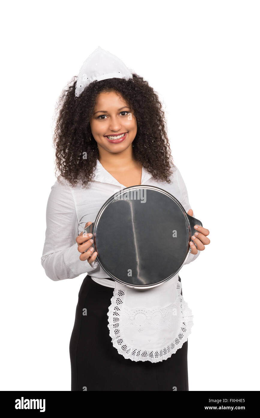 Cut out image of a young smiling maid with brown curly hair (afro) who is holding an empty tablet with both hands. The woman is Stock Photo