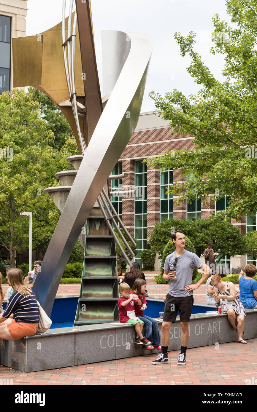 People sit and eat lunch in Boyd Plaza around Robert Carroll's fountain