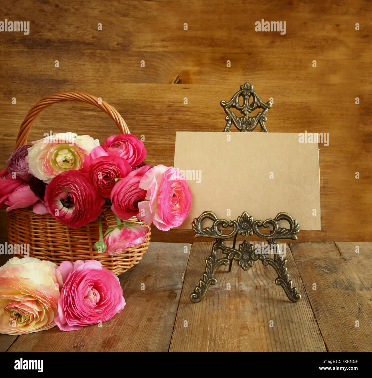 pink flowers in the basket next to empty card. mother's day concept. copy space. Stock Photo