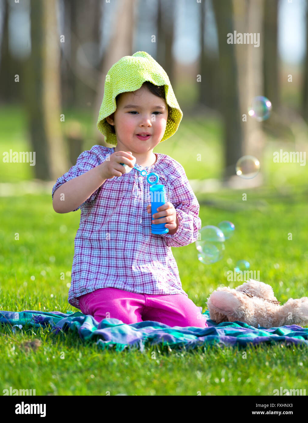 Portrait of funny lovely little girl blowing soap bubbles Stock Photo