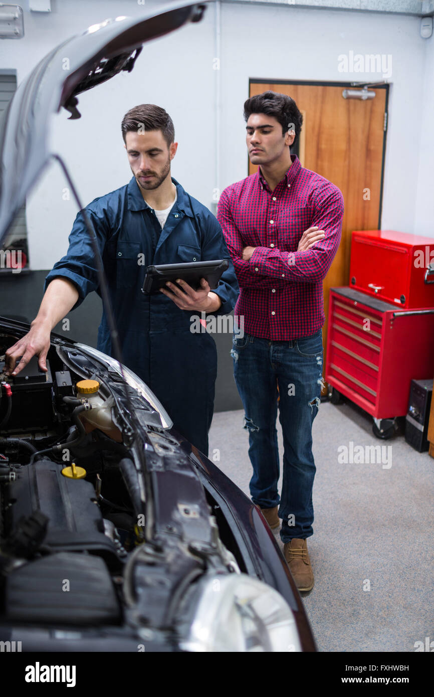 Mechanic showing customer the problem with car using diagnostic tool Stock Photo Alamy