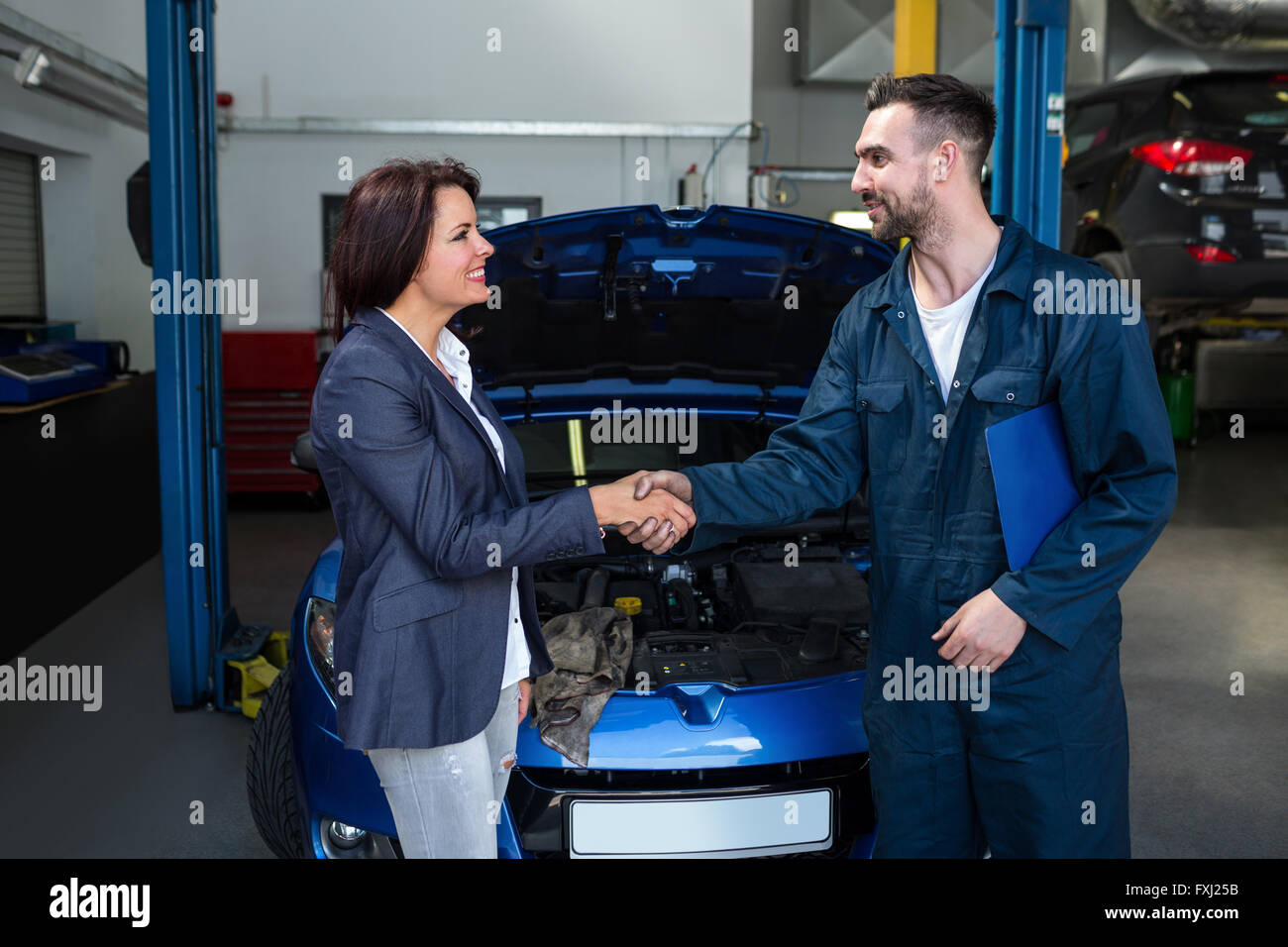 Satisfied customer shaking hands with mechanic Stock Photo