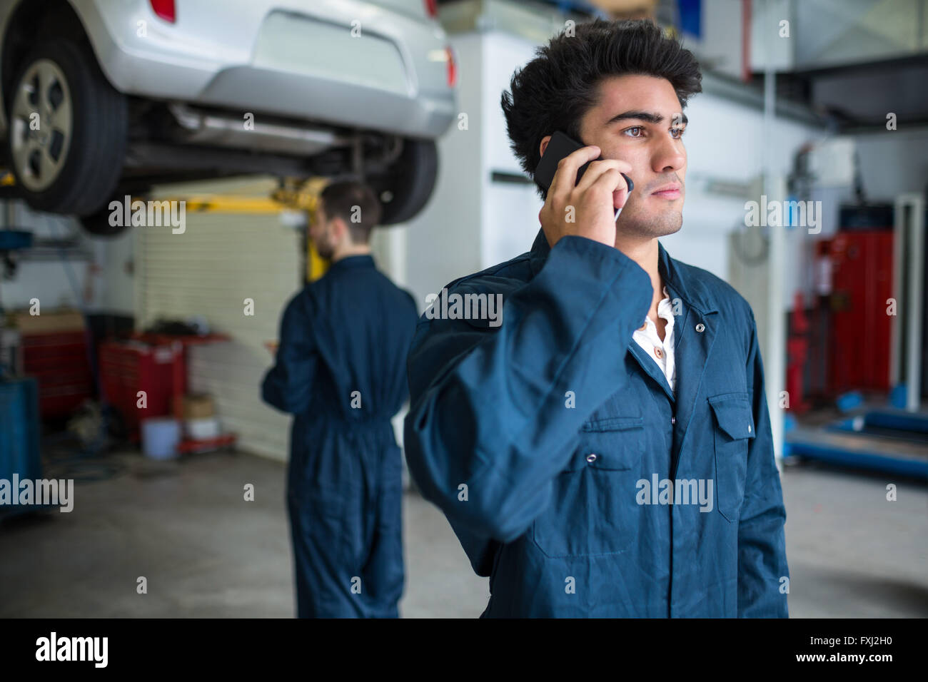 Mechanic talking on a mobile phone Stock Photo Alamy