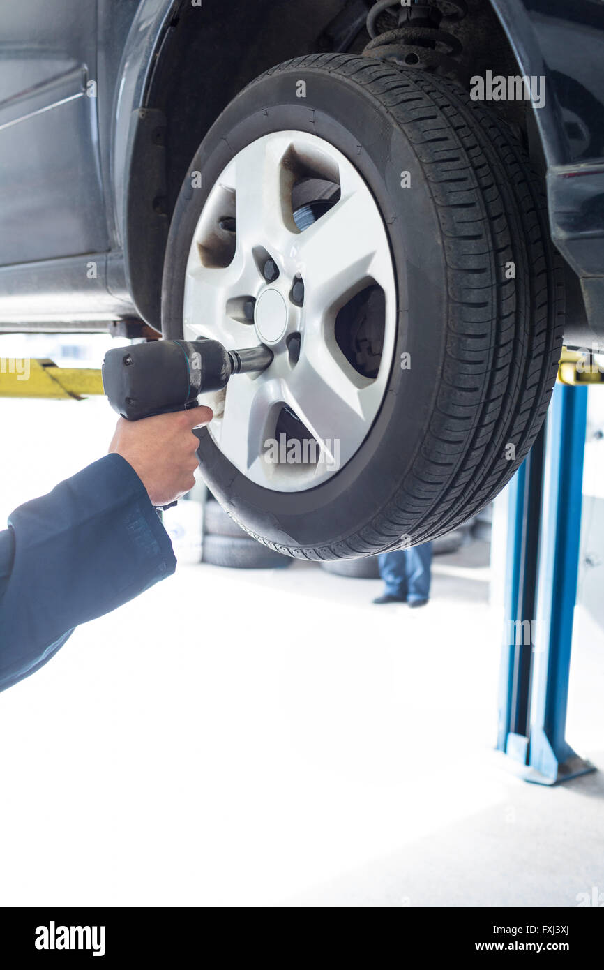 Mechanics hand fixing a car wheel Stock Photo