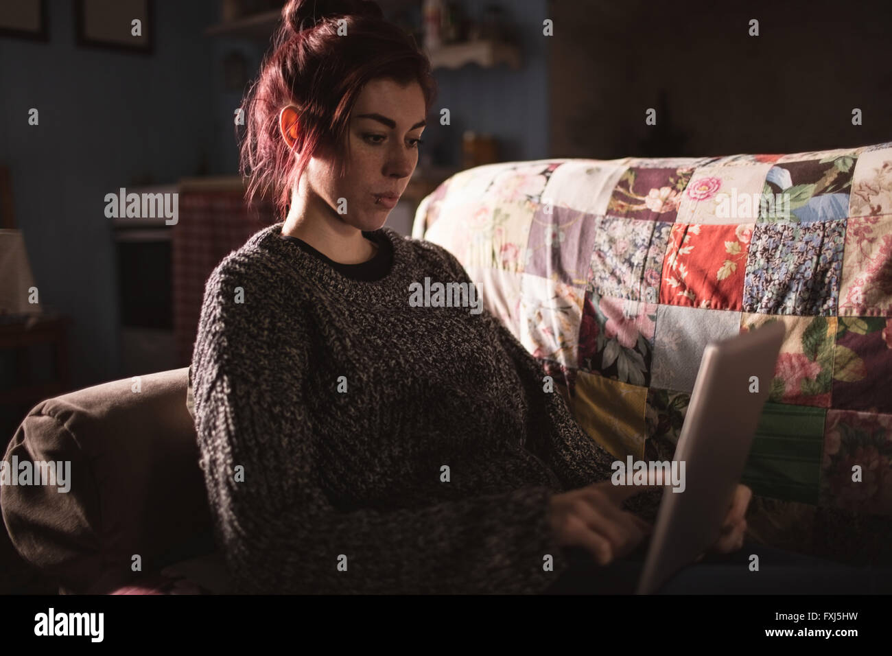 Young woman using digital tablet in living room Stock Photo - Alamy