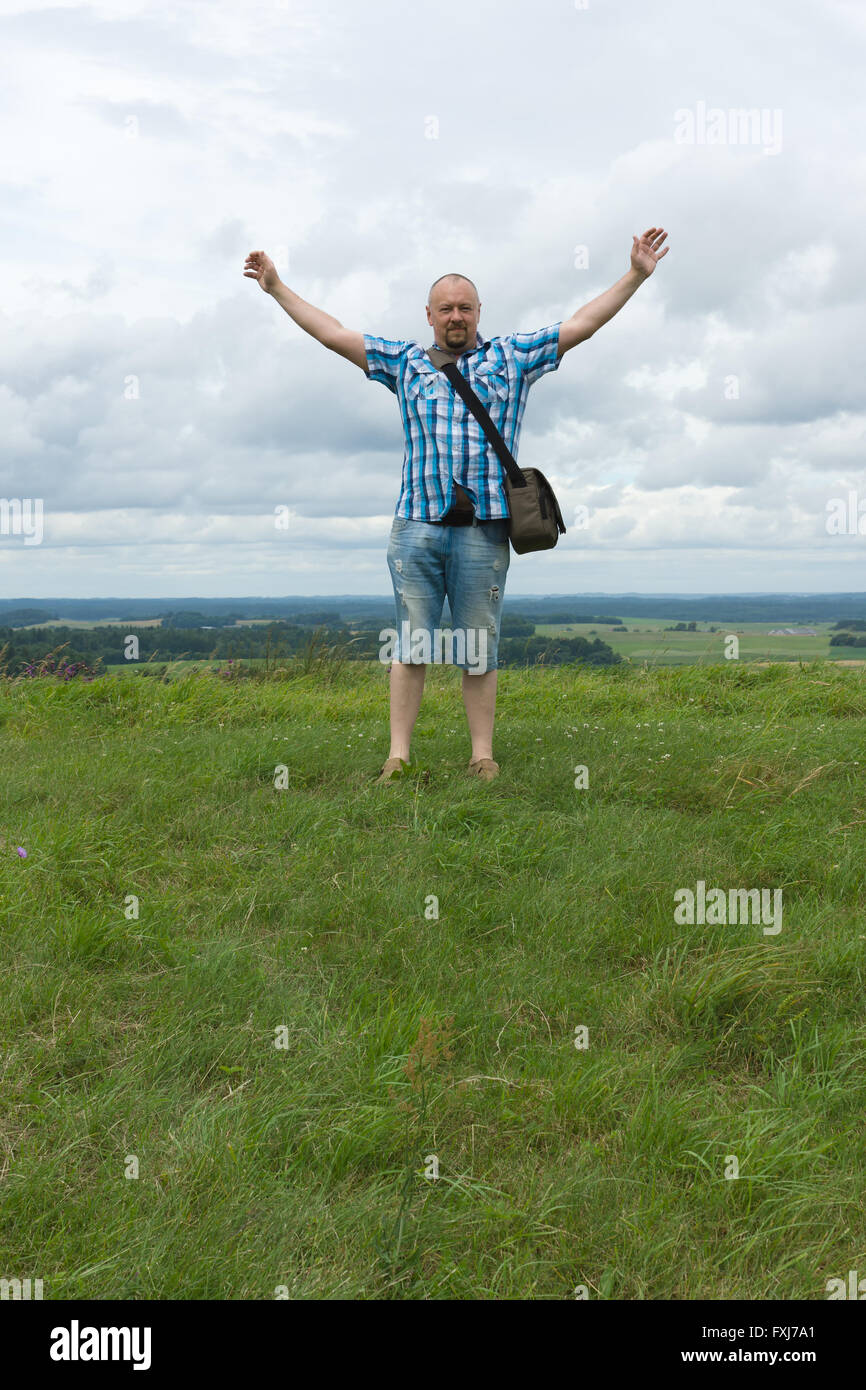 the man in a checkered shirt rejoices to conquest of the hill Stock Photo