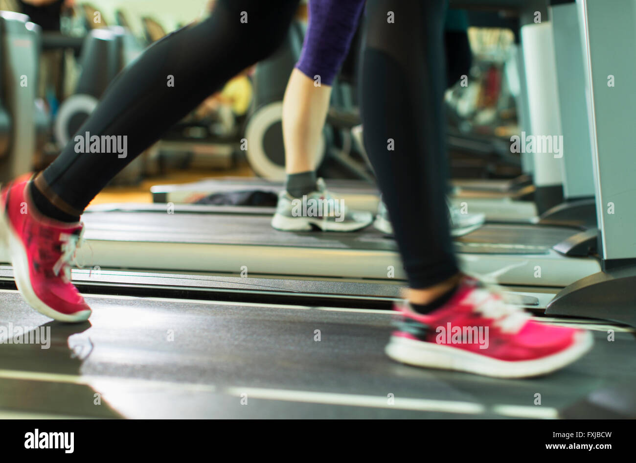Woman’s legs running on treadmill at gym Stock Photo