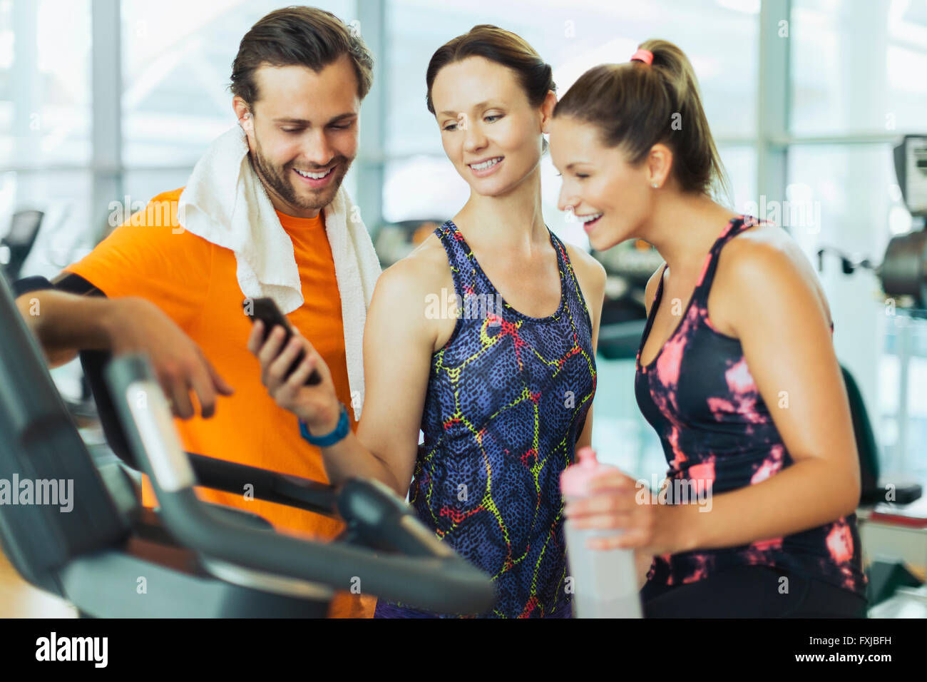 Friends using cell phone at gym Stock Photo