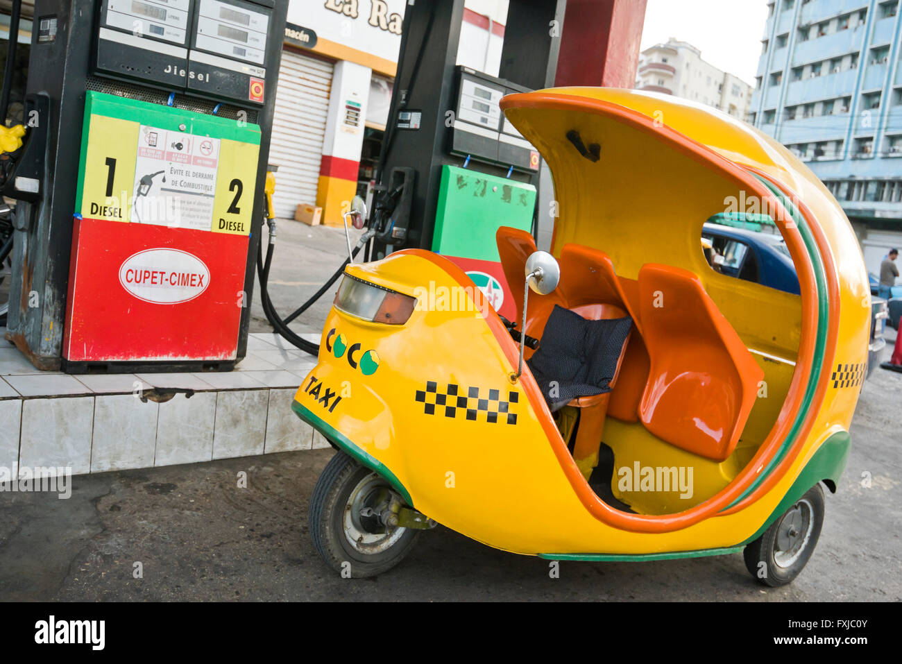 Horizontal view of a coco taxi on a petrol station forecourt in Havana, Cuba. Stock Photo