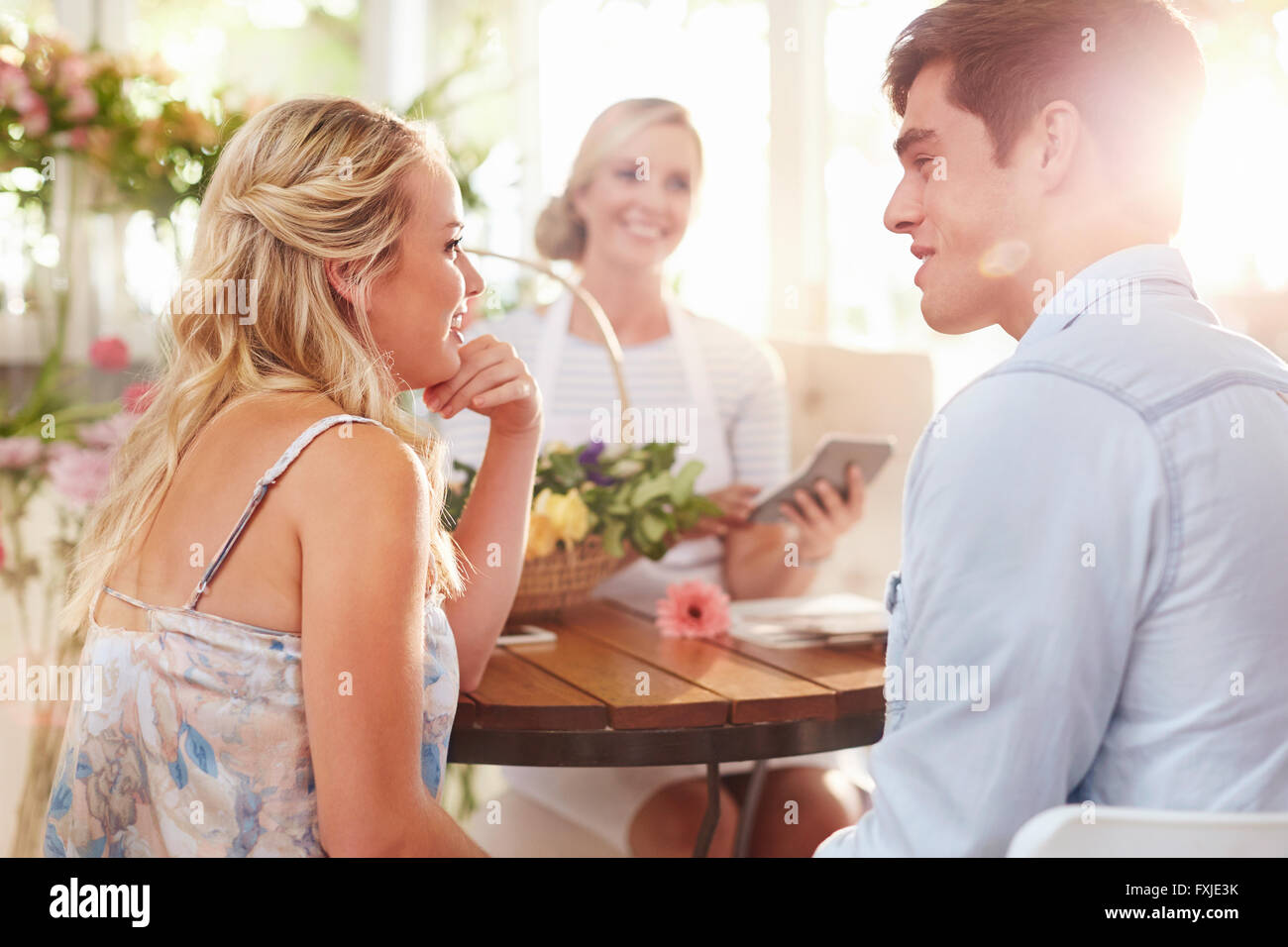 Couple talking with florist in flower shop Stock Photo