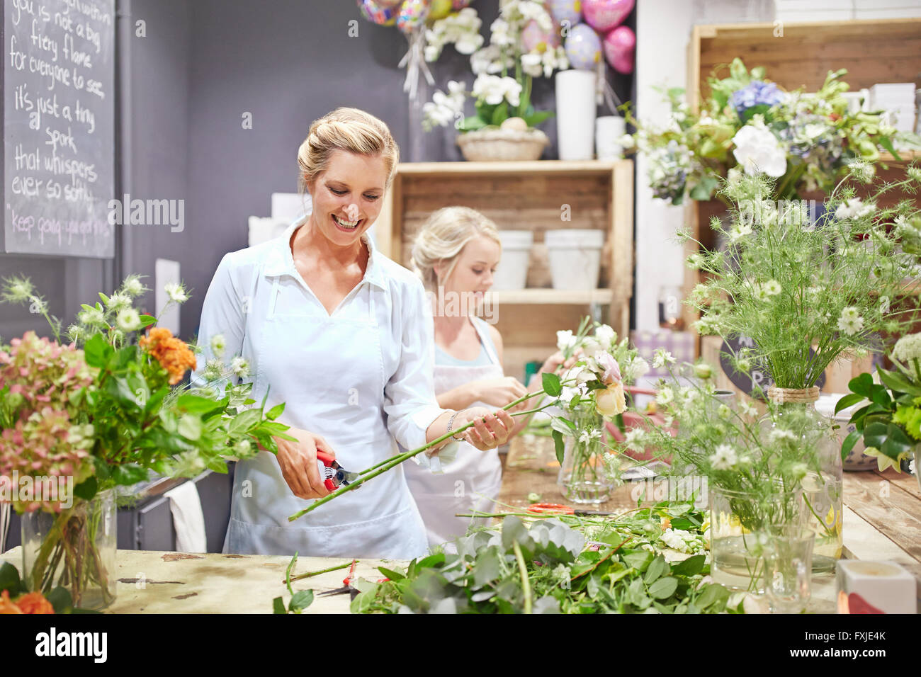 Smiling florists arranging bouquets in flower shop Stock Photo