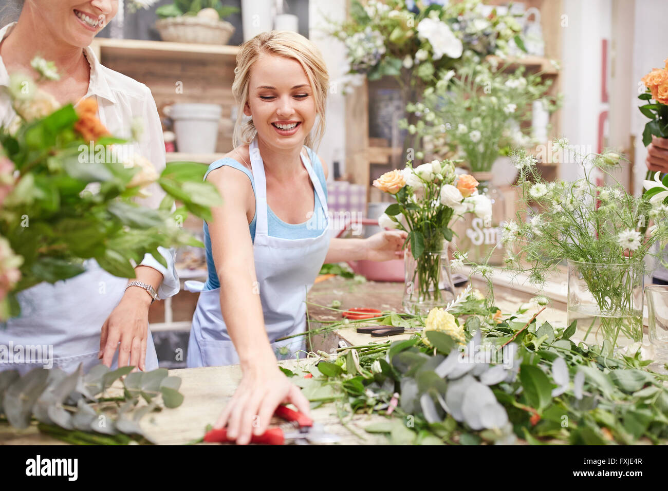 Smiling florist arranging bouquet in flower shop Stock Photo