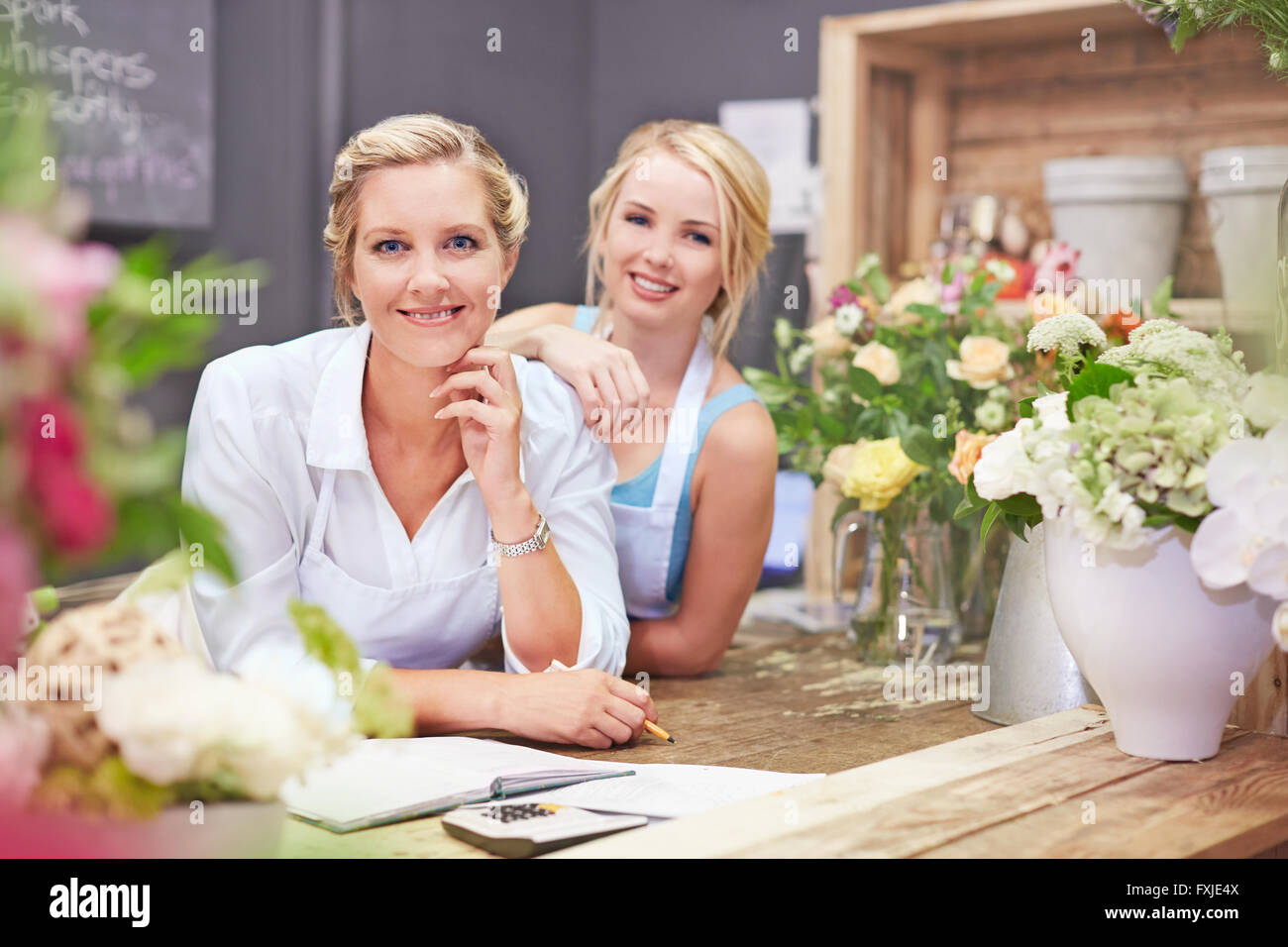 Portrait smiling florists in flower shop Stock Photo