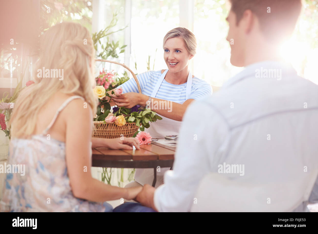 Florist discussing flowers with couple in flower shop Stock Photo