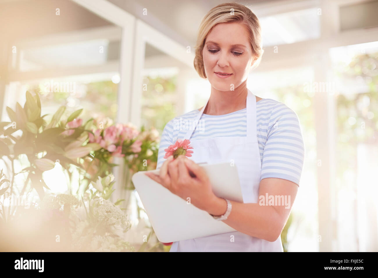 Florist with clipboard in flower shop Stock Photo