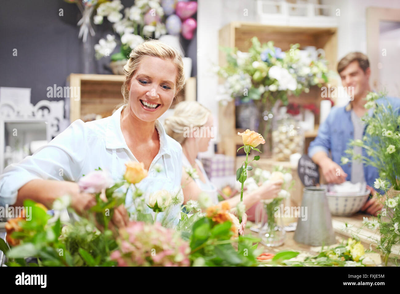 Smiling florist arranging bouquet in flower shop Stock Photo
