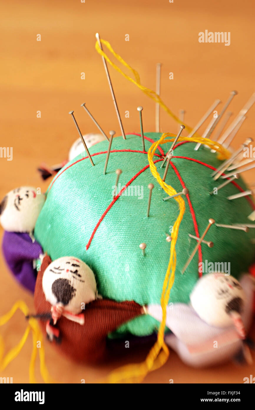 Pincushion with little figures of Chinese men surrounding it. Shot with