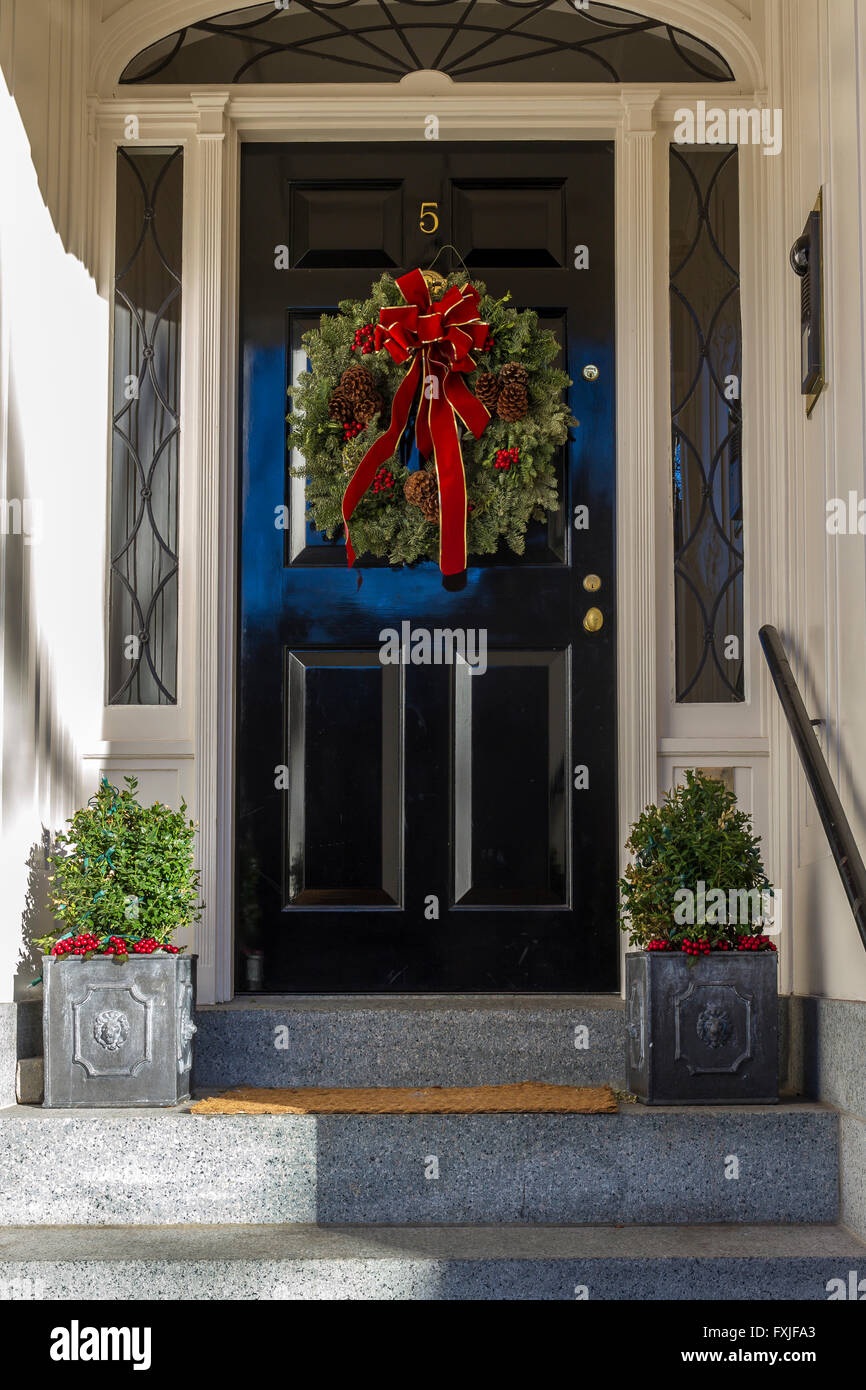 A Christmas wreath or garland  hanging on a front entrance door on a house in the Beacon Hill district of Boston, Boston,  Massachusetts, USA Stock Photo