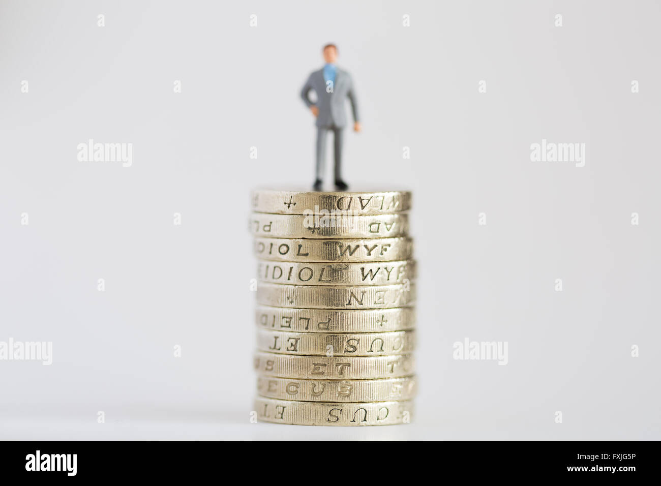Close up/macro model stock photo depicting working business man on £1 pound coin stack Stock Photo