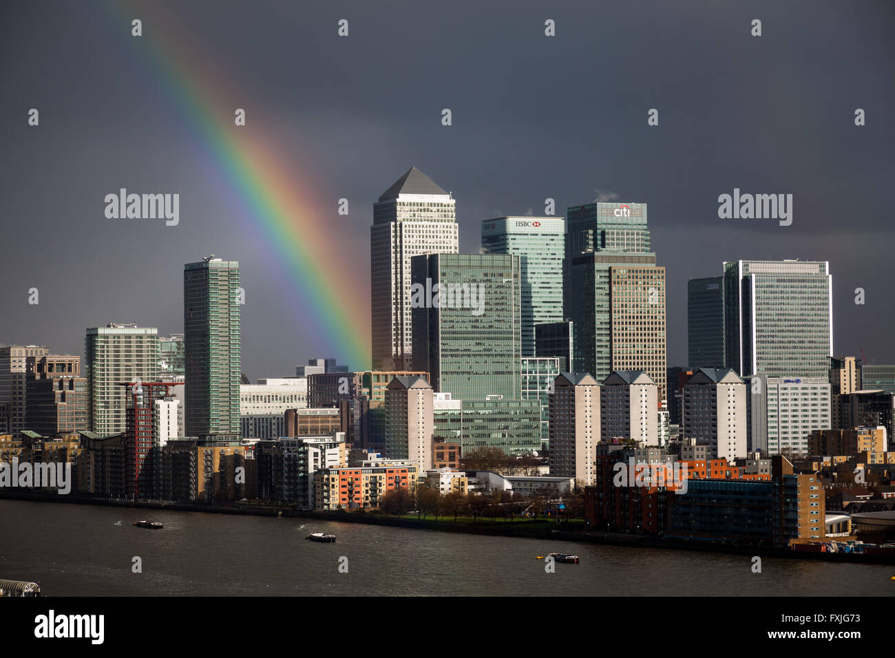 A colourful rainbow over south east London including Canary Wharf business park buildings, UK. Stock Photo