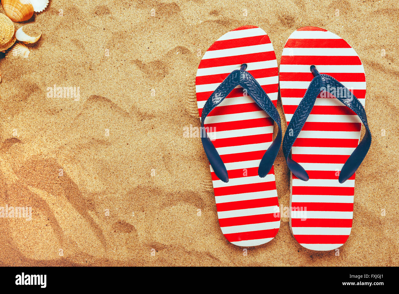 Pair of thongs or flip flops on beach sand, top view of summer holiday ...