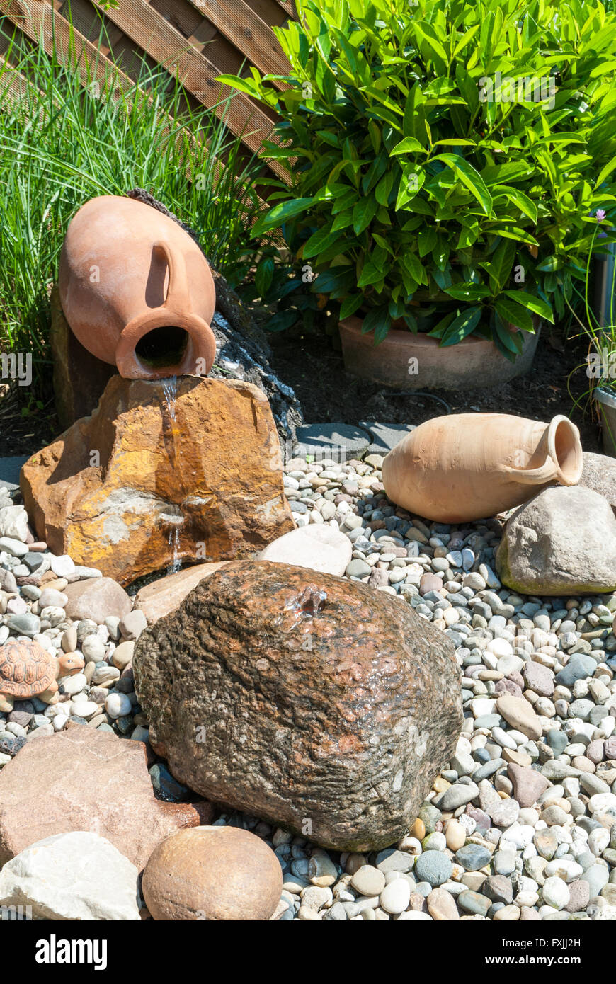 Water feature with amphoras and bolder in an ornamental garden Stock