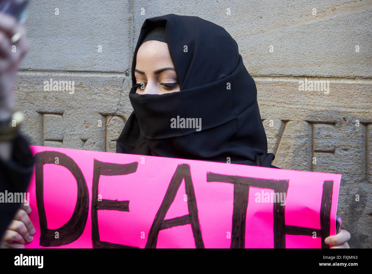Rona- A young Muslim-American lady shows her disapproval of the hate rhetoric coming from Donald Trump by holding up a pink sign Stock Photo