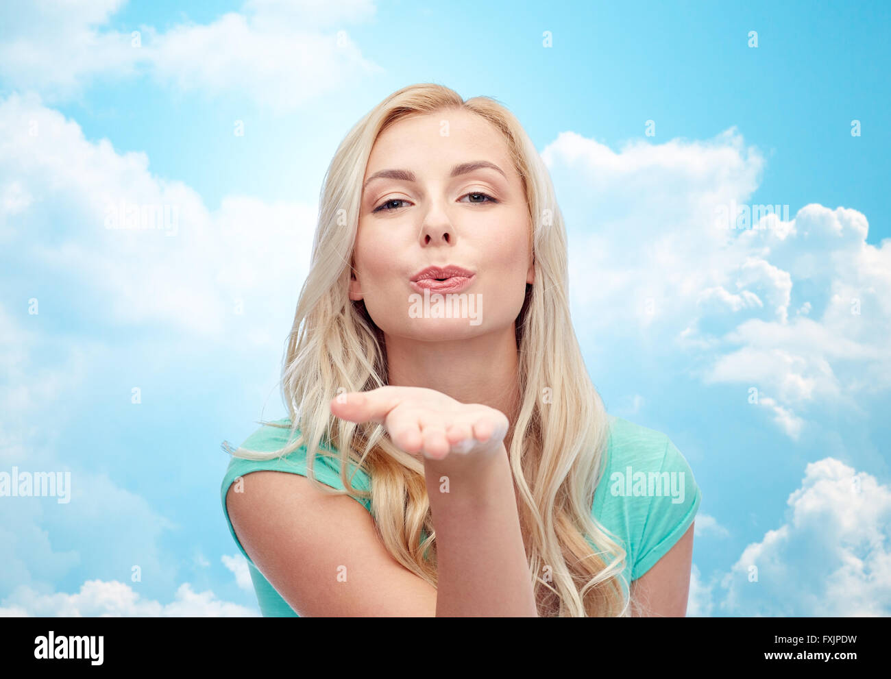 smiling young woman or teen girl sending blow kiss Stock Photo