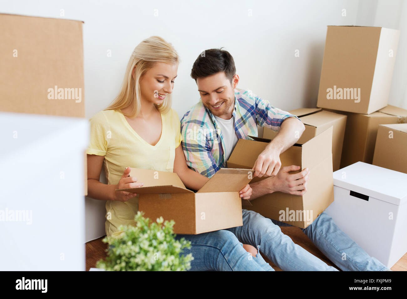 smiling couple with many boxes moving to new home Stock Photo - Alamy