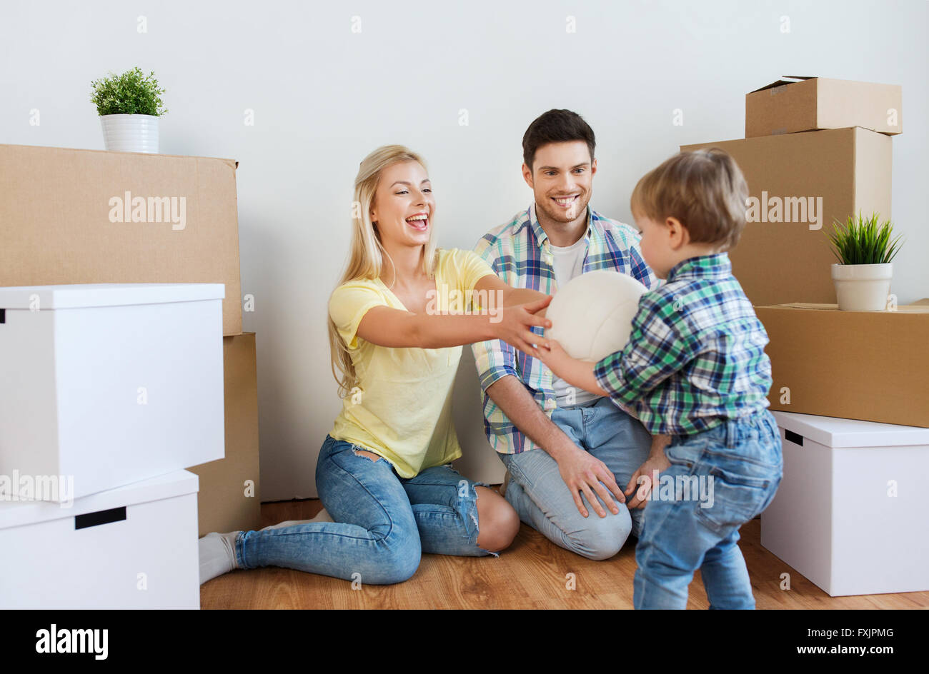 happy family moving to new home and playing ball Stock Photo - Alamy
