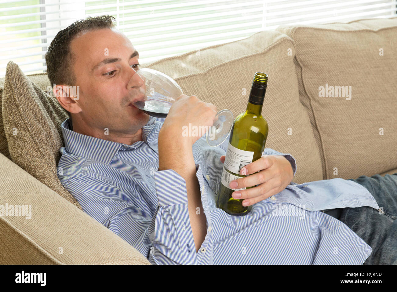 man drinking a whole bottle of wine Stock Photo