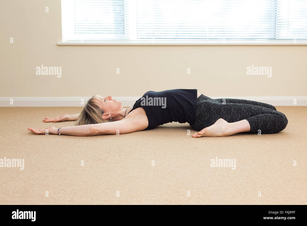 female in a yoga pose indoors Stock Photo