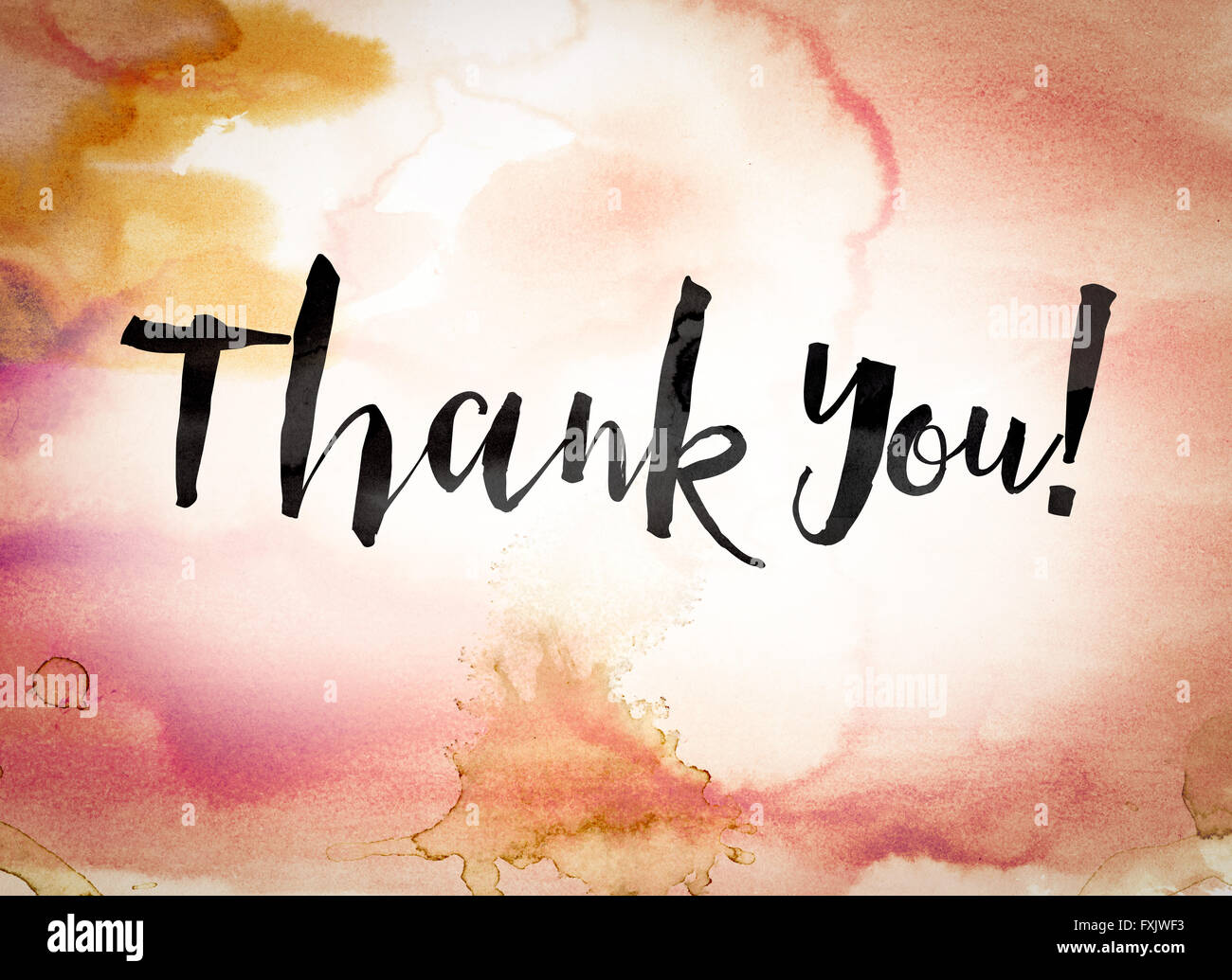 The word "Thank you" written in black paint on a colorful watercolor washed background. Stock Photo