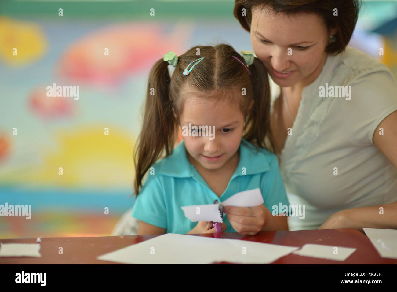 Mother with girl cutting together Stock Photo Alamy