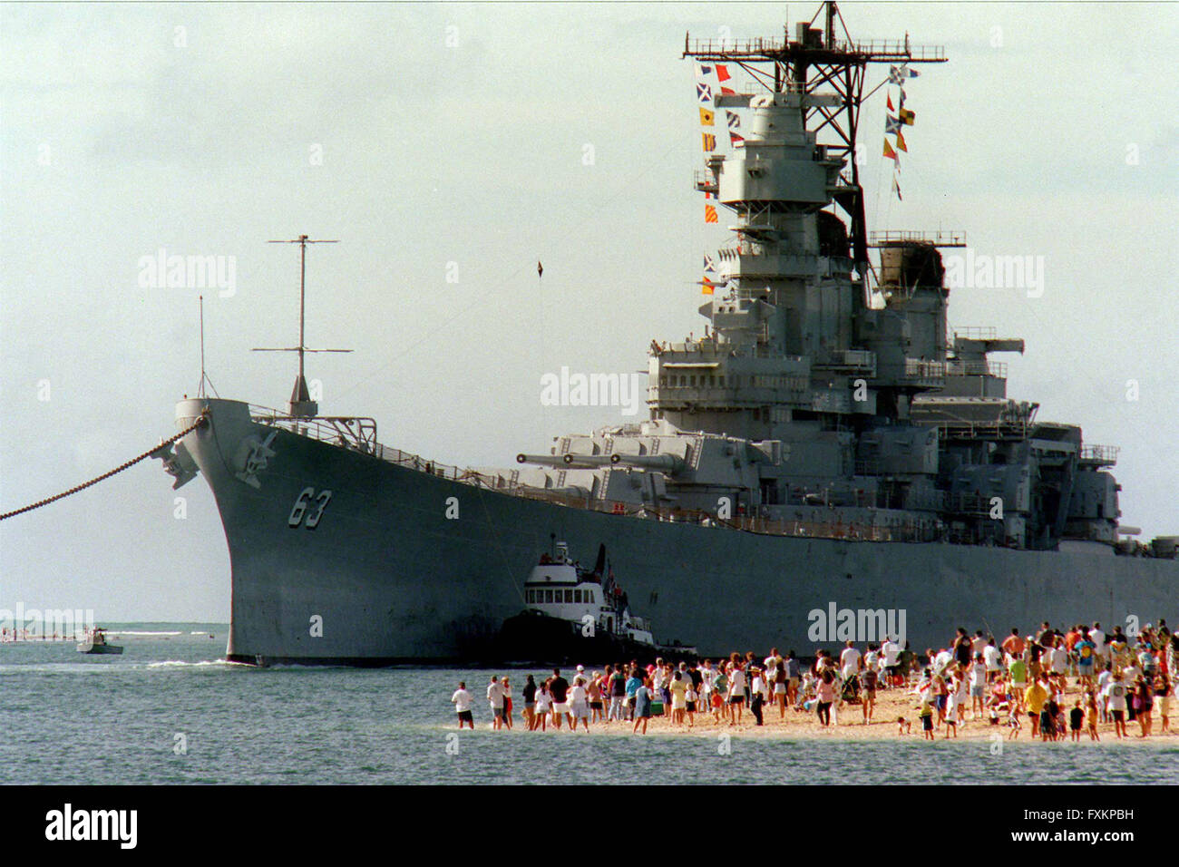 Pearl Harbor, Hawaii, USA. 22nd June, 1998. People gather on the beach to see the battleship USS Missouri (BB 63) enter the channel into Pearl Harbor, Hawaii, on June 22, 1998. United States Secretary of the Navy John H. Dalton signed the Donation Agreement on May 4th, allowing Missouri to be used as a museum near the Arizona Memorial. The ship was towed from Bremerton, Washington. Mandatory Credit: David Weideman/U.S. Navy via CNP © David Weideman/CNP/ZUMA Wire/Alamy Live News Stock Photo