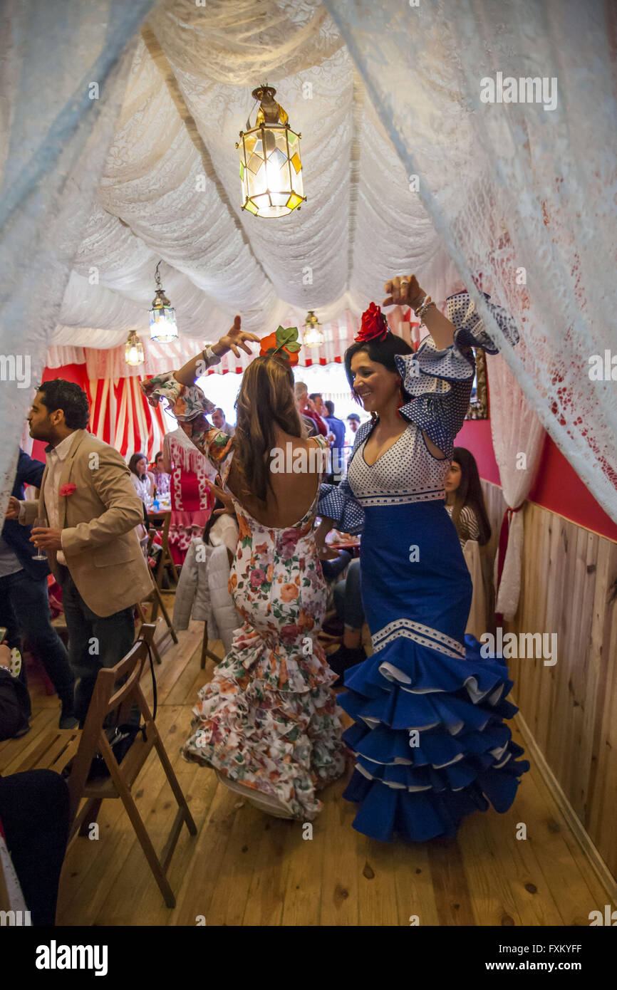 Seville, Spain. 16th Apr, 2016. Two Women dressed in flamenco dress dance traditional ''sevillanas'' in a fair booth at the ''Feria de Abril'' (April's Fair) 2016 © Daniel Gonzalez Acuna/ZUMA Wire/Alamy Live News Stock Photo
