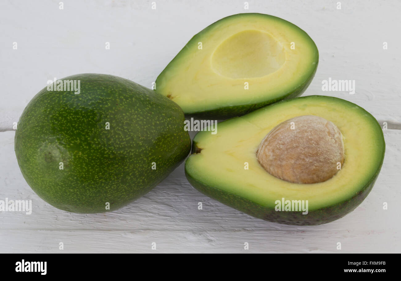 Photo of whole and cut avocados on rustic white wood table Stock Photo ...