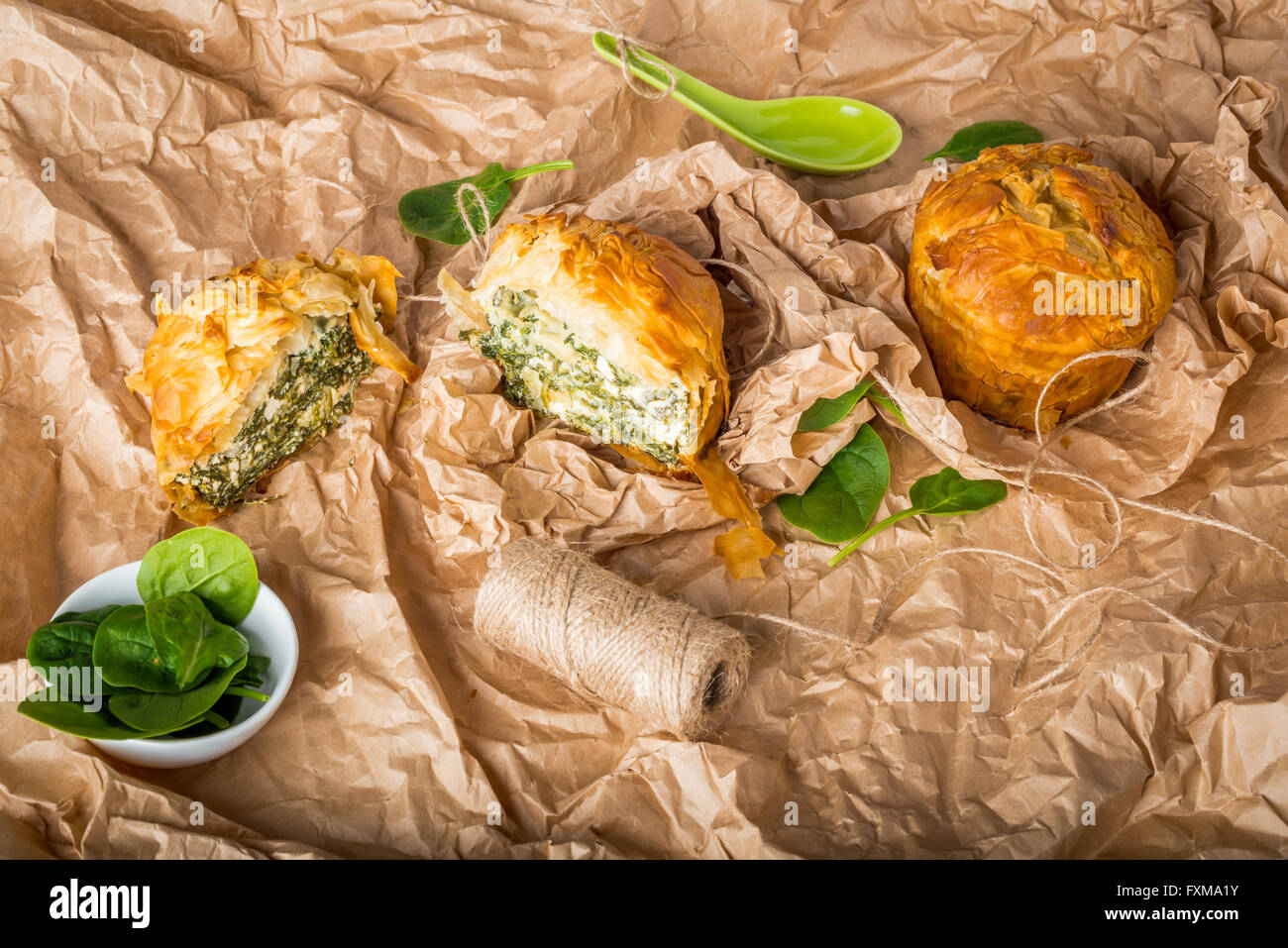 Spanakopita - sliced Greek spinach pie with feta and ricotta, street food on wrapping paper Stock Photo