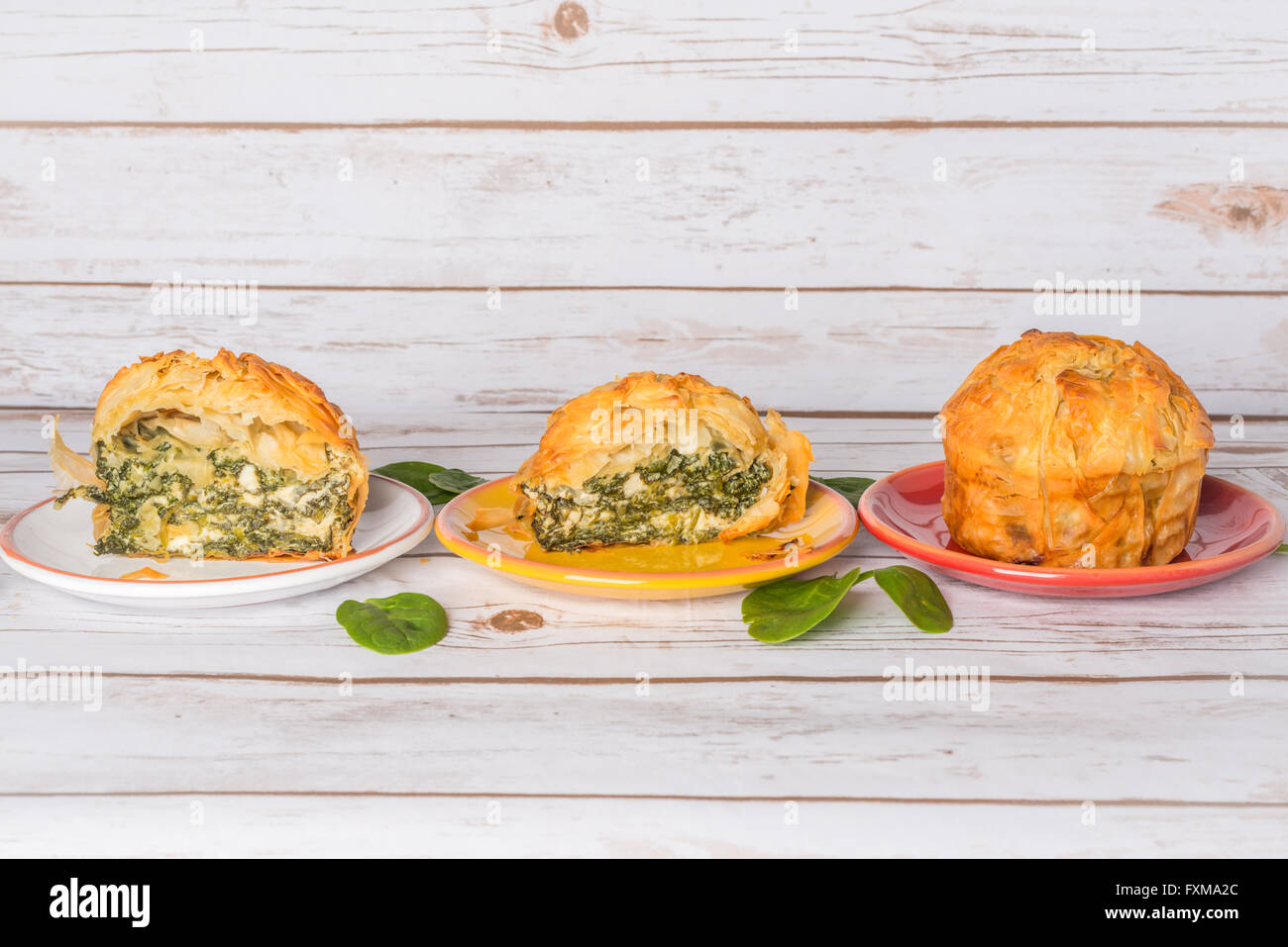 Homemade Spanakopita - Greek spinach pie with feta and ricotta, sliced on plates Stock Photo