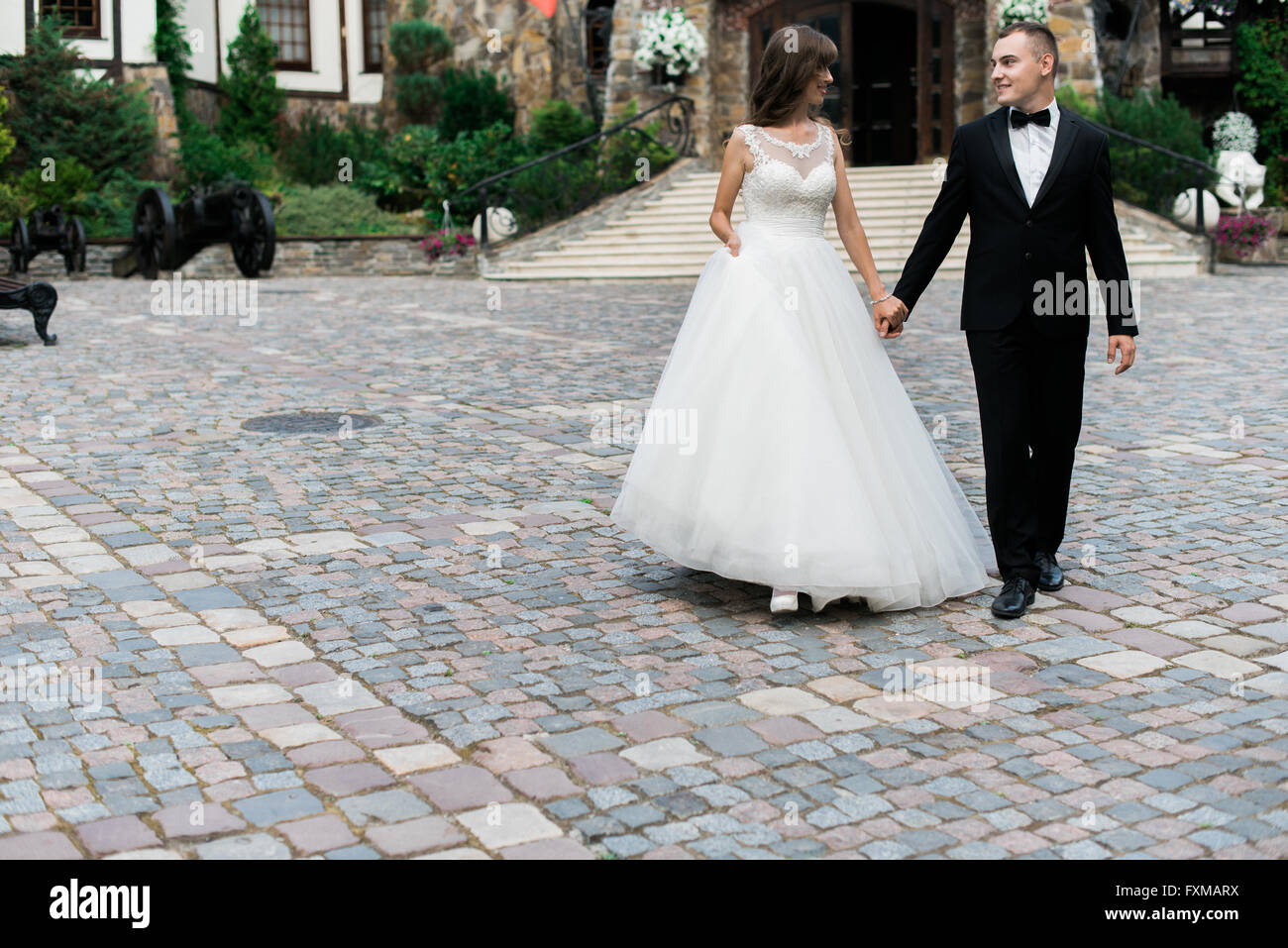 Beautiful young married couple walking and holding hands Stock Photo ...