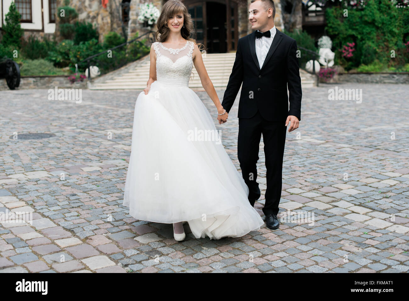 Beautiful young married couple walking and holding hands Stock Photo ...