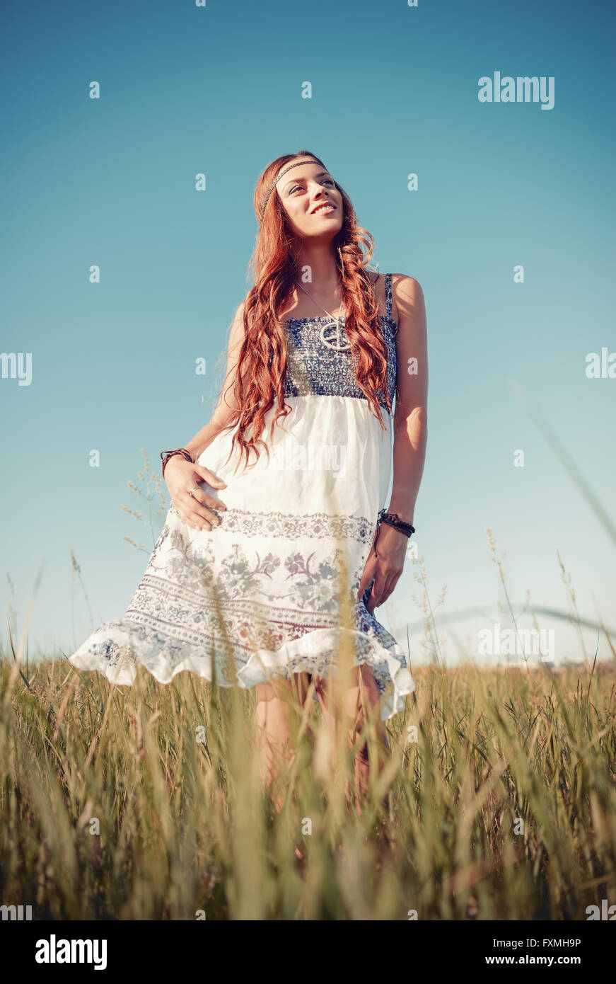Smiling pretty hippie woman standing in the meadow Stock Photo