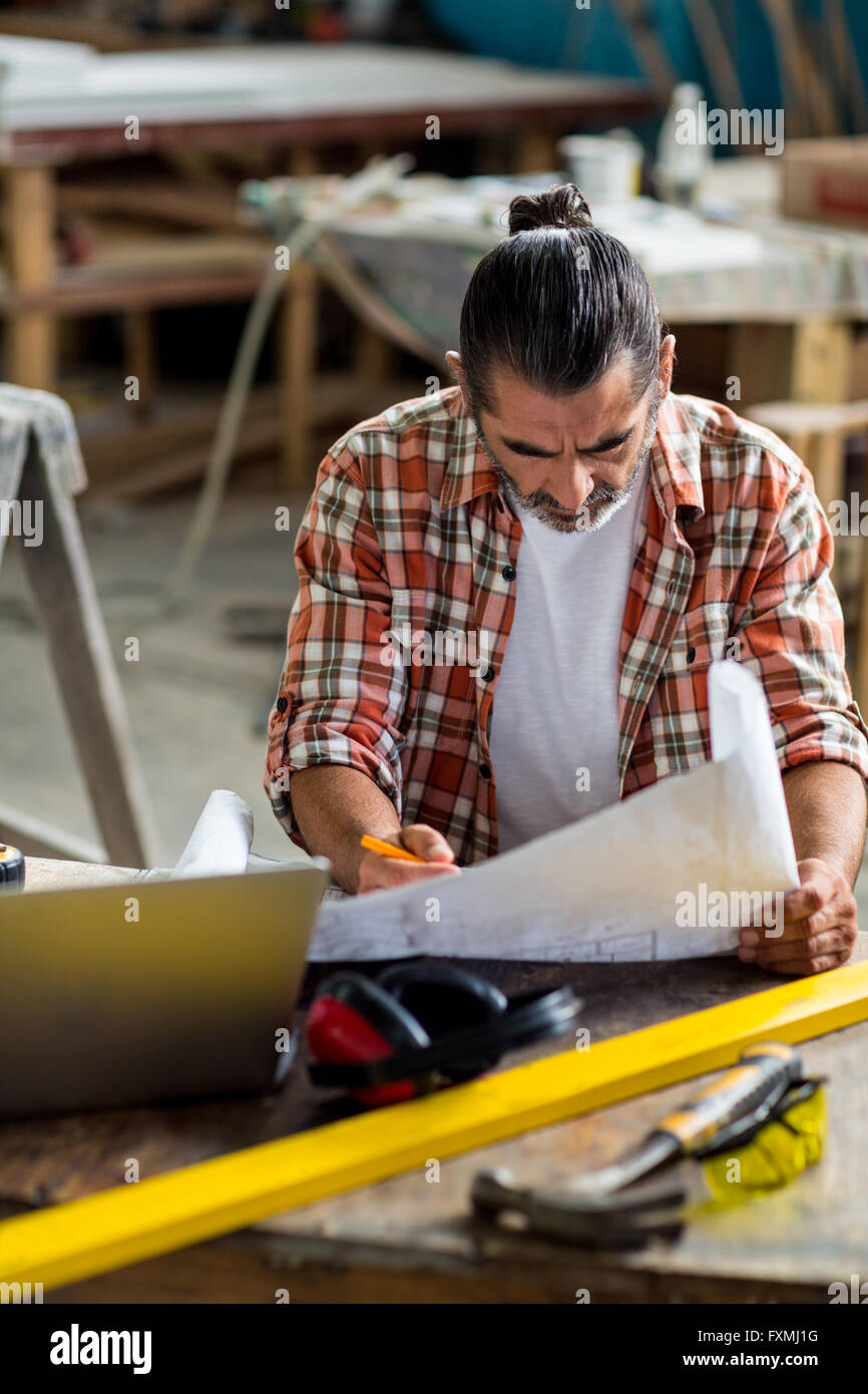 Carpenter looking at a blueprint Stock Photo - Alamy