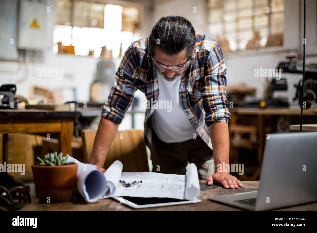 Carpenter looking at a blueprint Stock Photo - Alamy