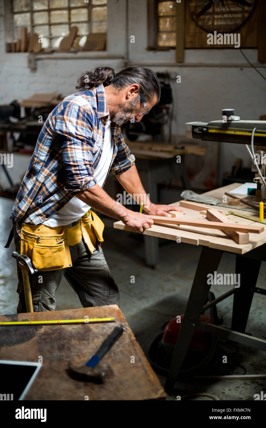 Carpenter marking on wooden plank with pencil Stock Photo Alamy
