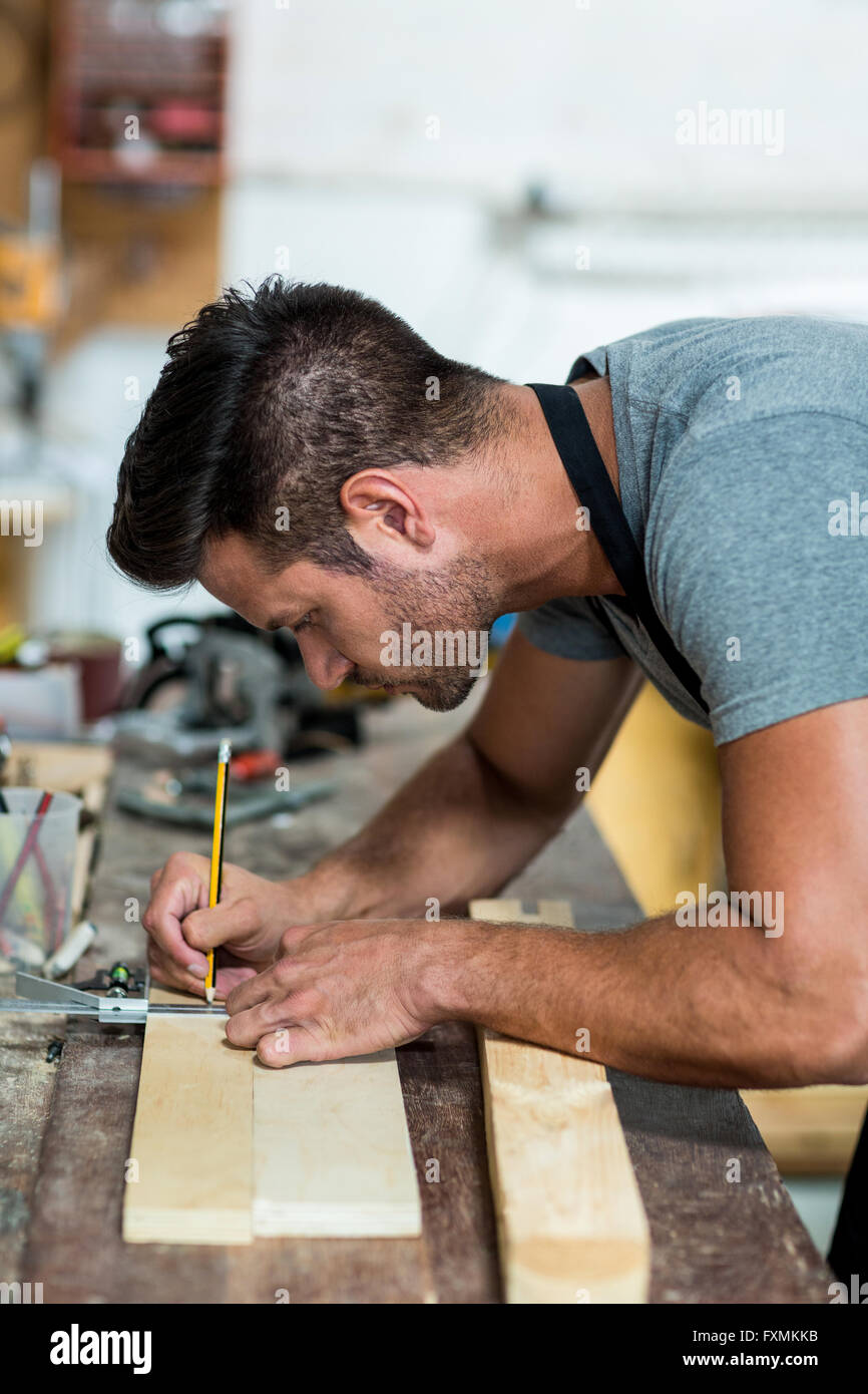 Carpenter marking on wooden plank with pencil Stock Photo Alamy