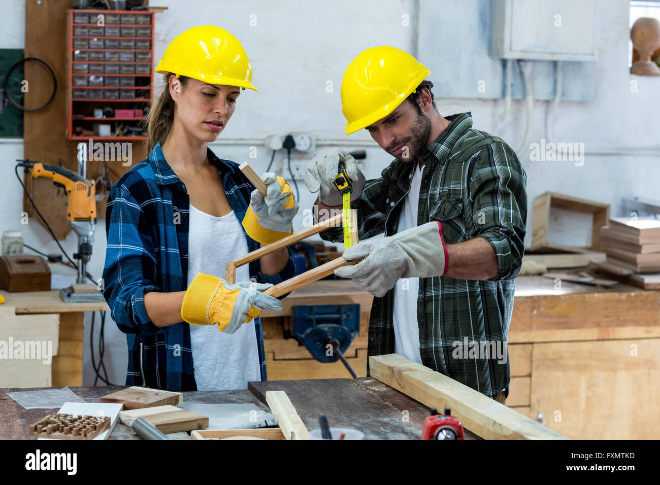 Male And Female Carpenters Measuring A Wooden Plank Stock Photo Alamy